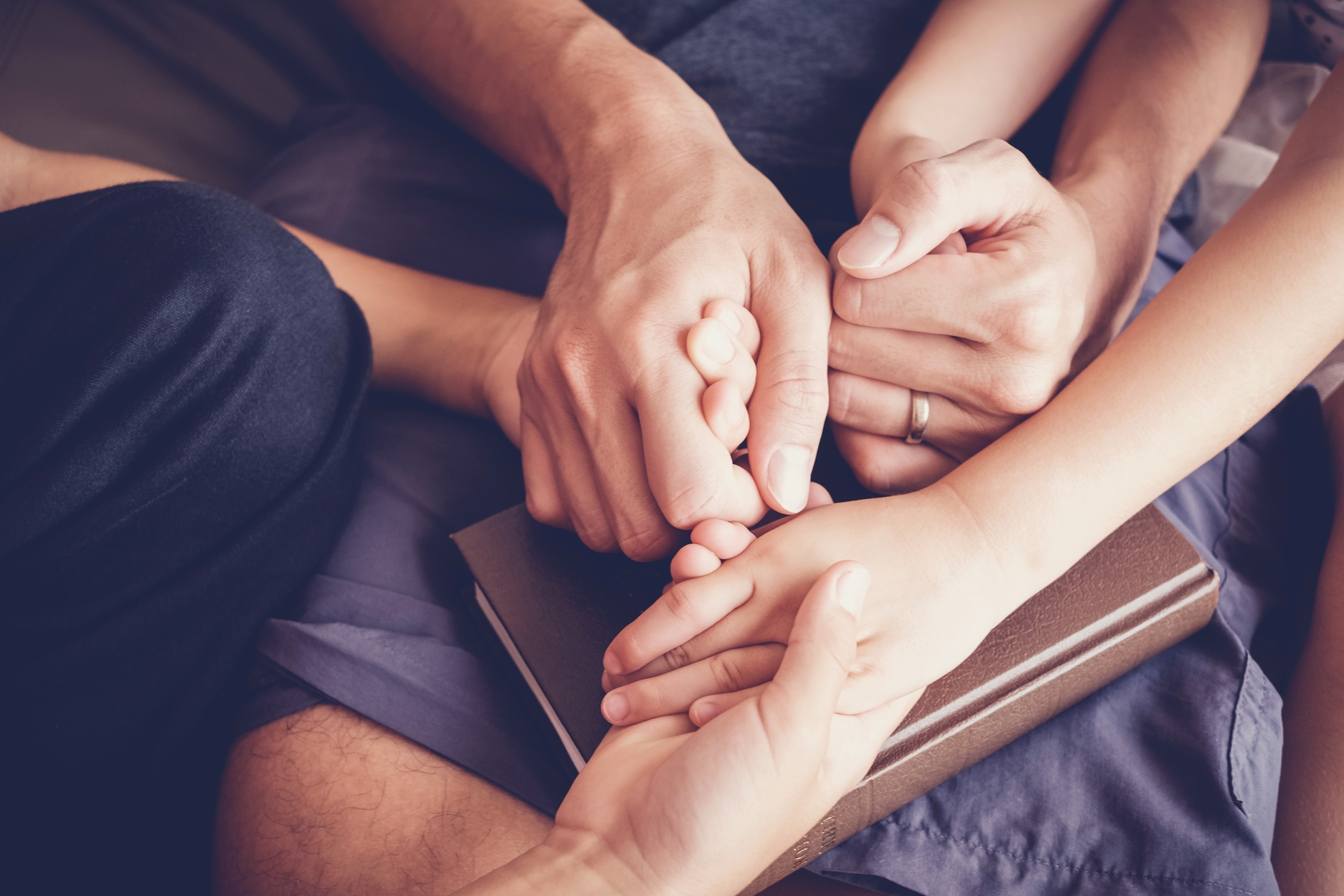 Holding hands over Bible